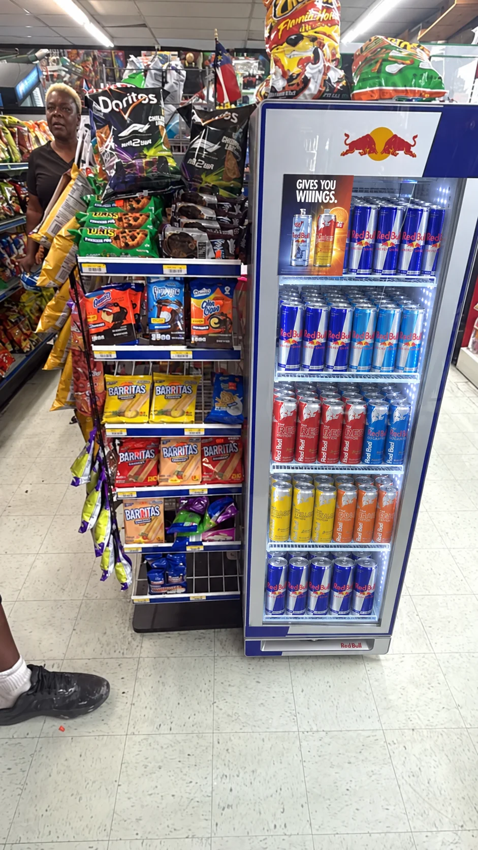 Snack shelves beside a cooler stocked with energy drinks